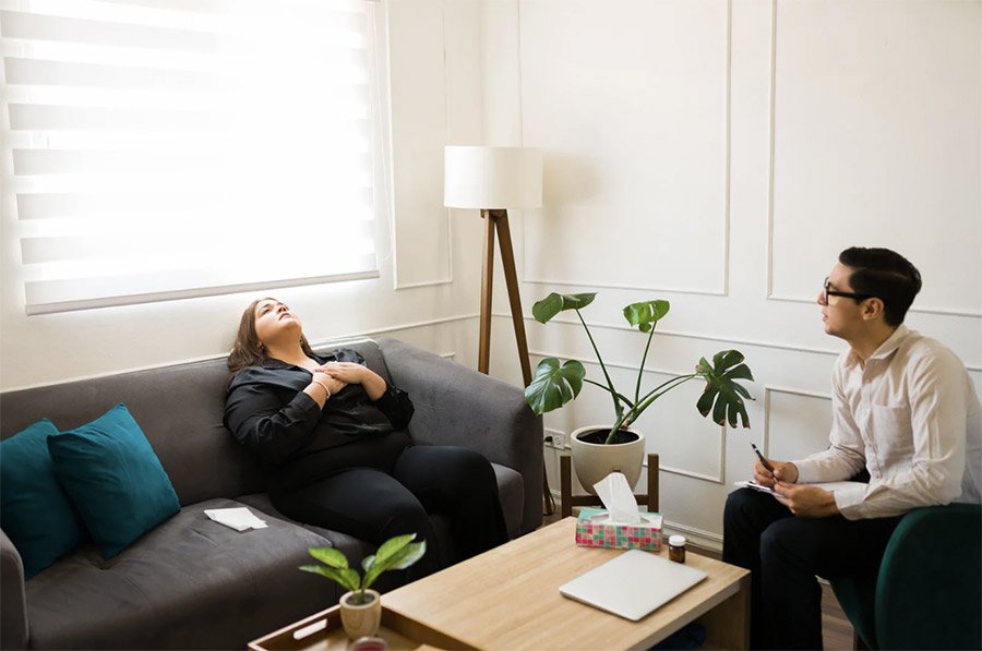 woman experiencing financial anxiety at therapist's office.