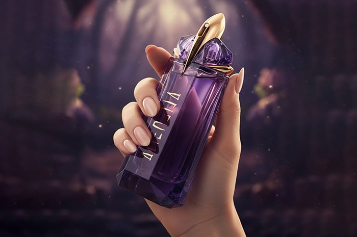 A pretty hand holding a bottle of Mugler perfume fragrance.
