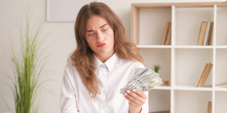 Money mindset woman holding a wad of cash